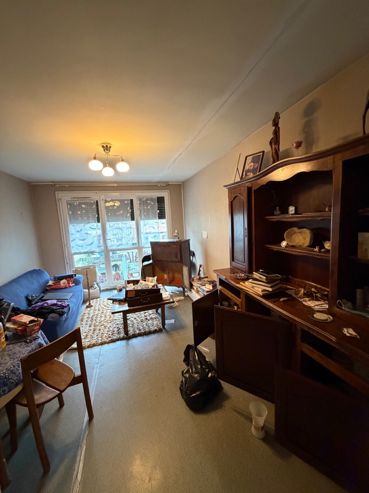 Séjour d'un appartement encombré de meubles, cartons et objets avant débarras à Béhobie
