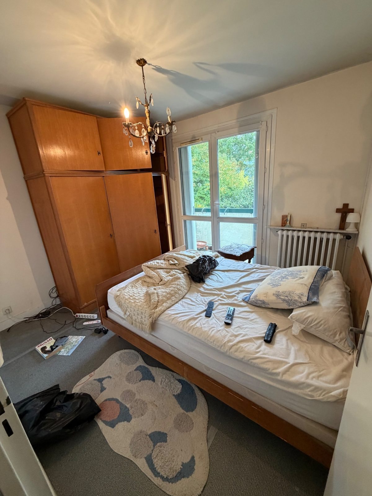 Chambre meublée d'un lit et d'une armoire en bois avant vide appartement à Béhobie