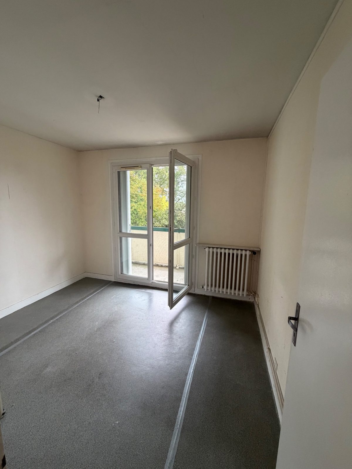 Chambre entièrement vidée, porte-fenêtre du balcon ouverte, après débarras à Béhobie