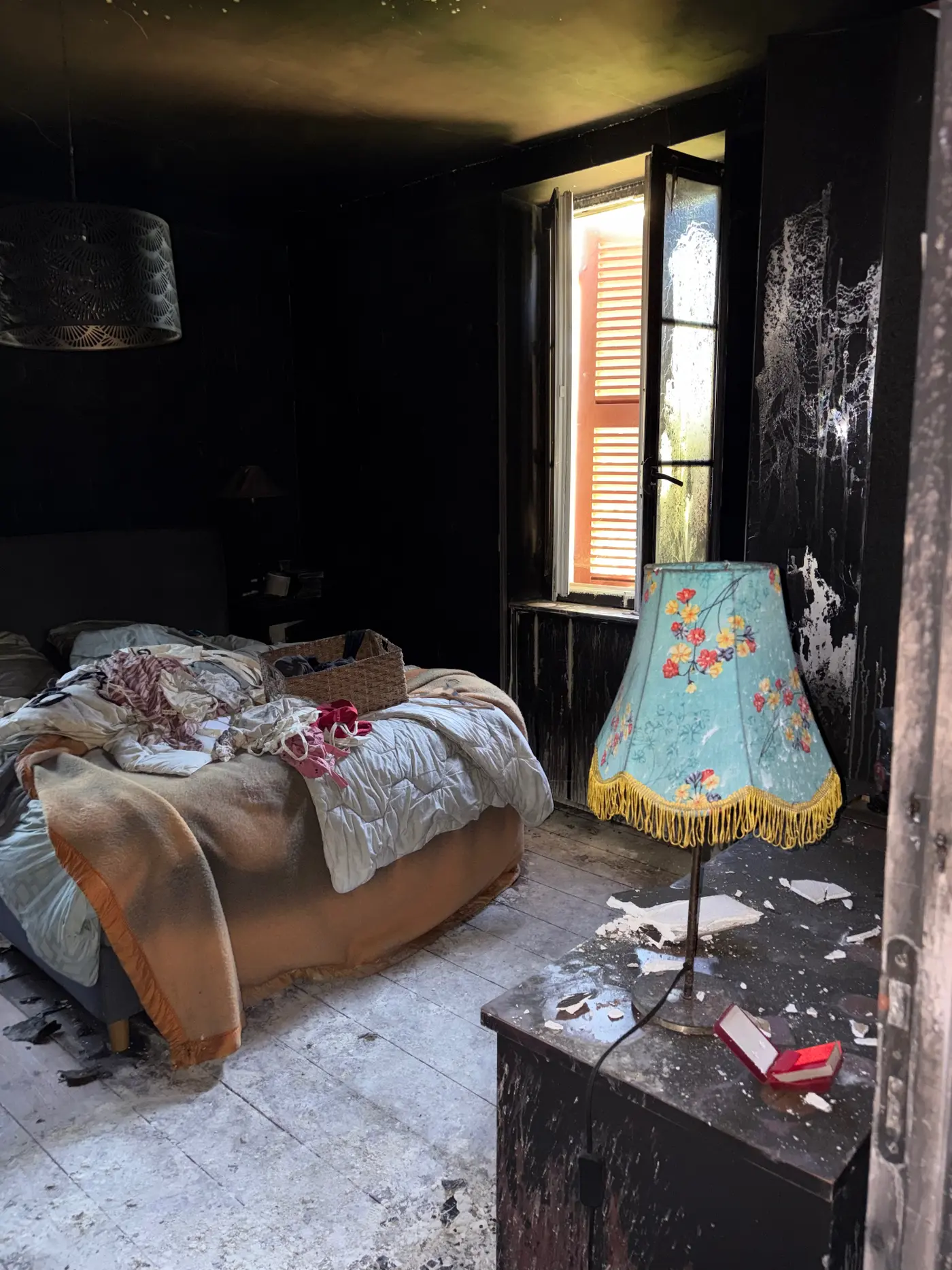 Chambre noircie par les suies après un incendie, avant débarras