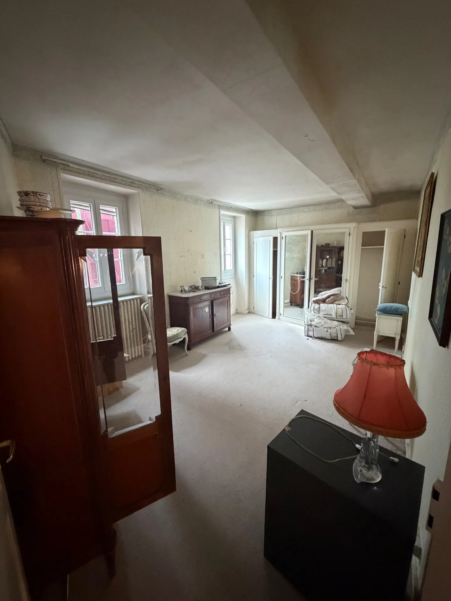 Chambre meublée avec armoire, commode en marbre et fauteuil, avant débarras