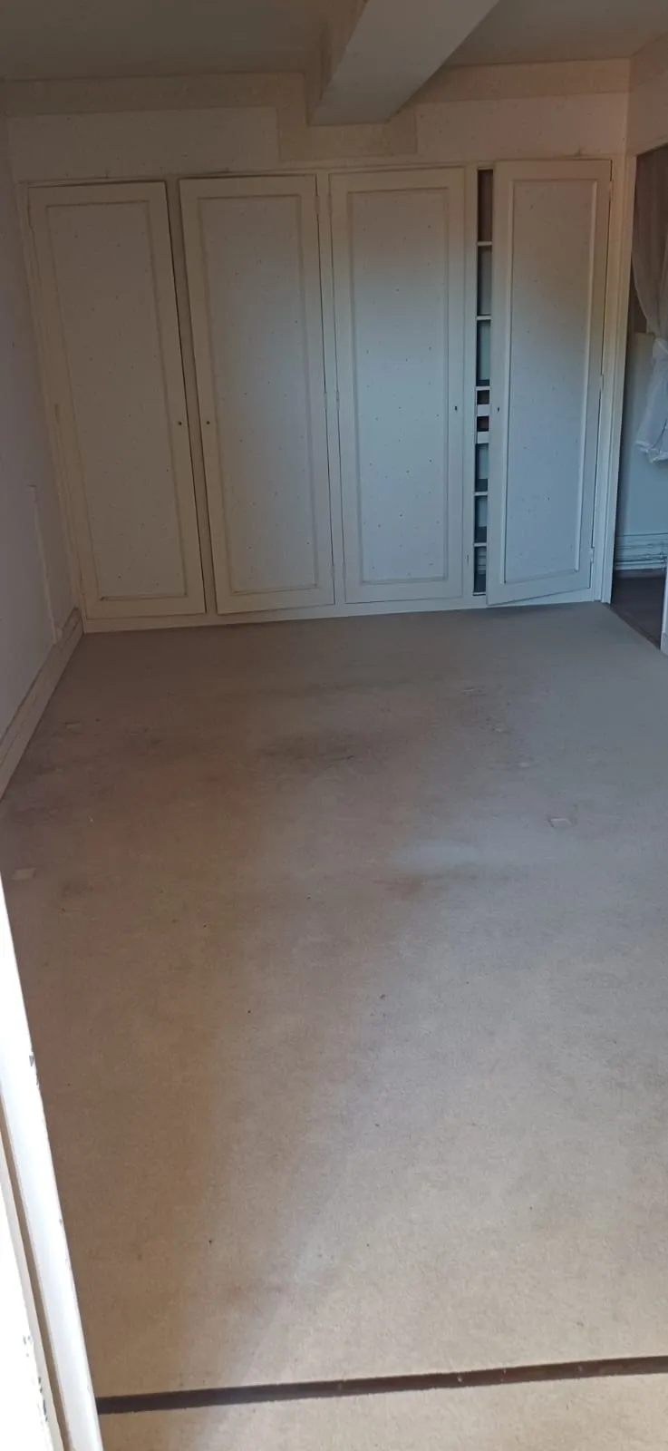 Pièce vide avec penderies encastrées, après débarras