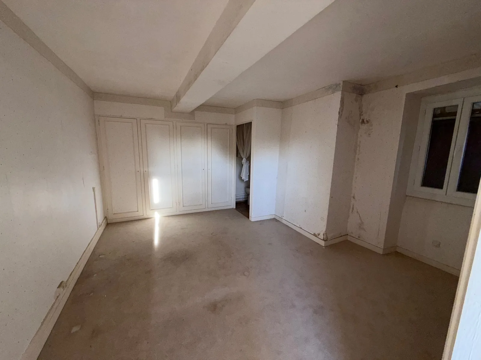 Chambre vide avec placards encastrés blancs, après débarras
