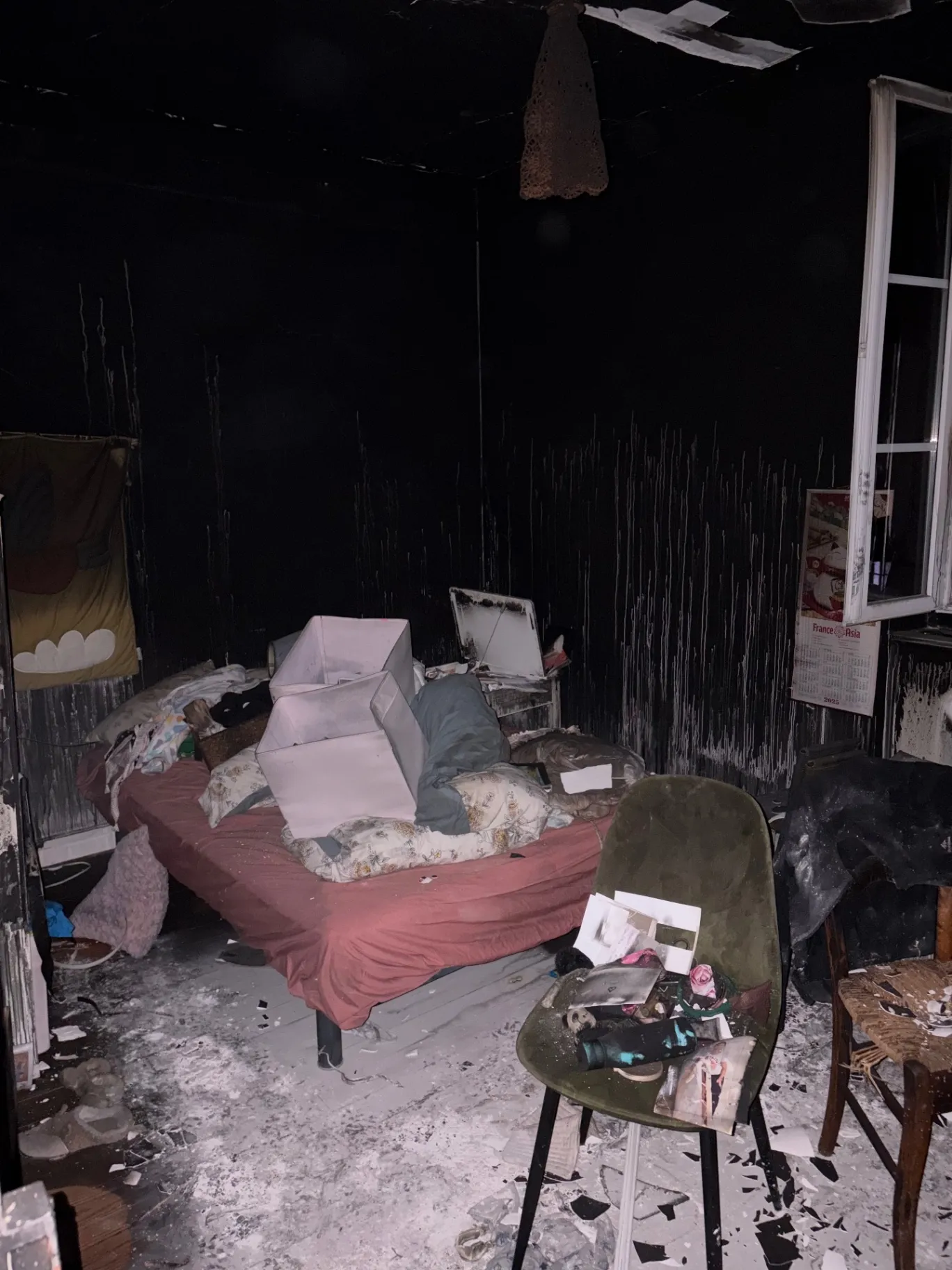 Chambre couverte de suie et de débris après un incendie, avant débarras